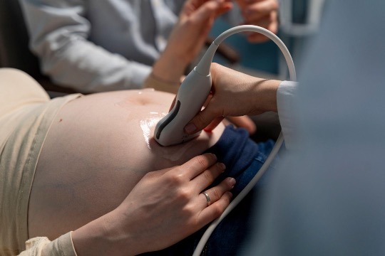 doctor performing ultrasound on pregnant lady
