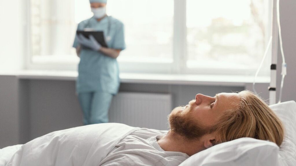 nurse watching over patient in bed