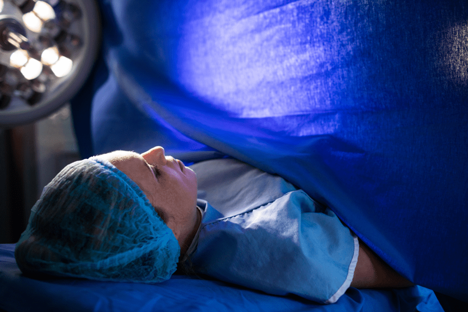 Patient in surgery with blue surgical drape