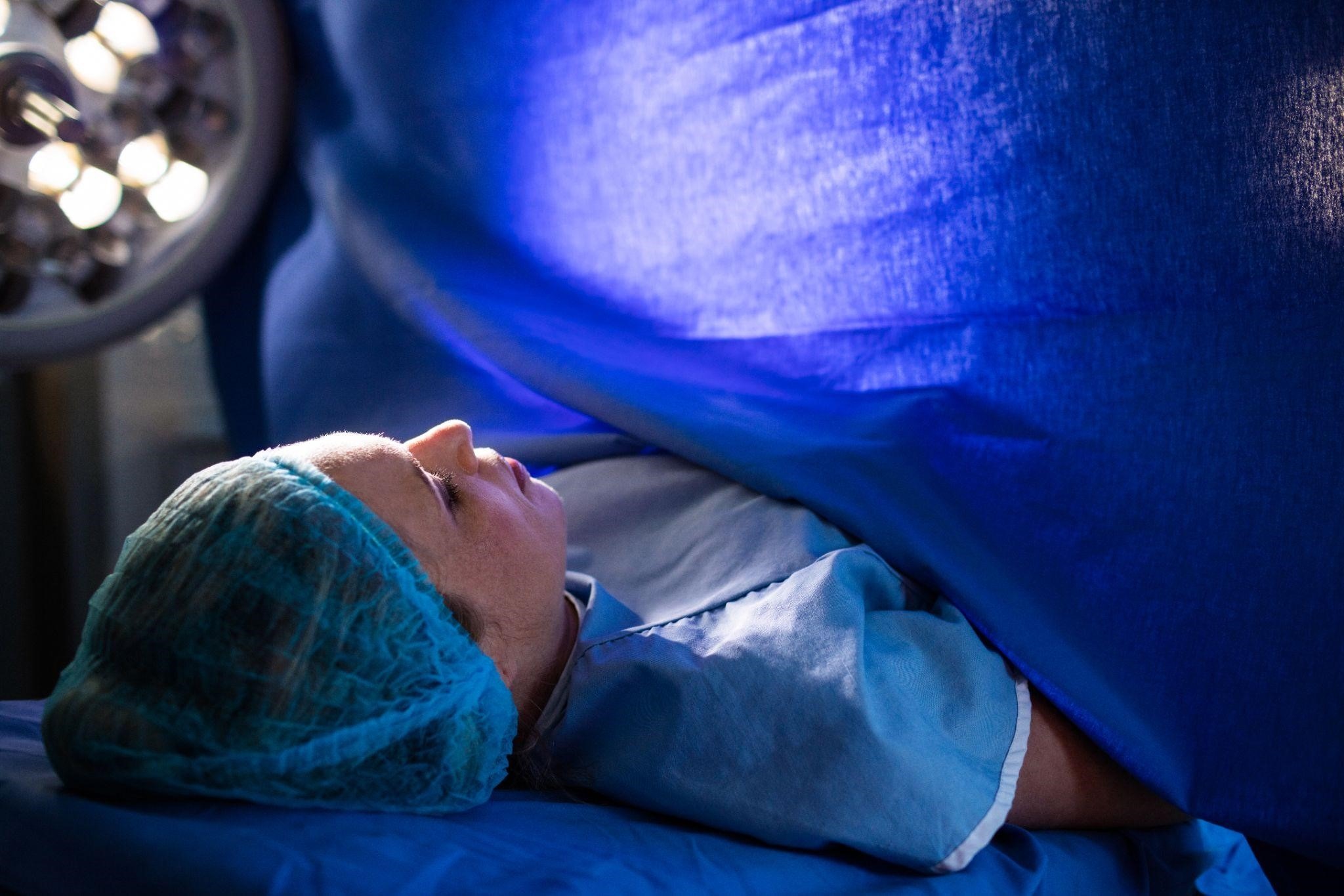 a woman in surgery with blue surgical drape