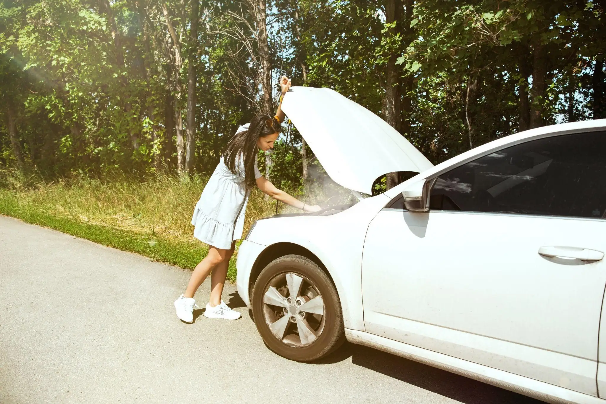 a lady opening the hood of the car