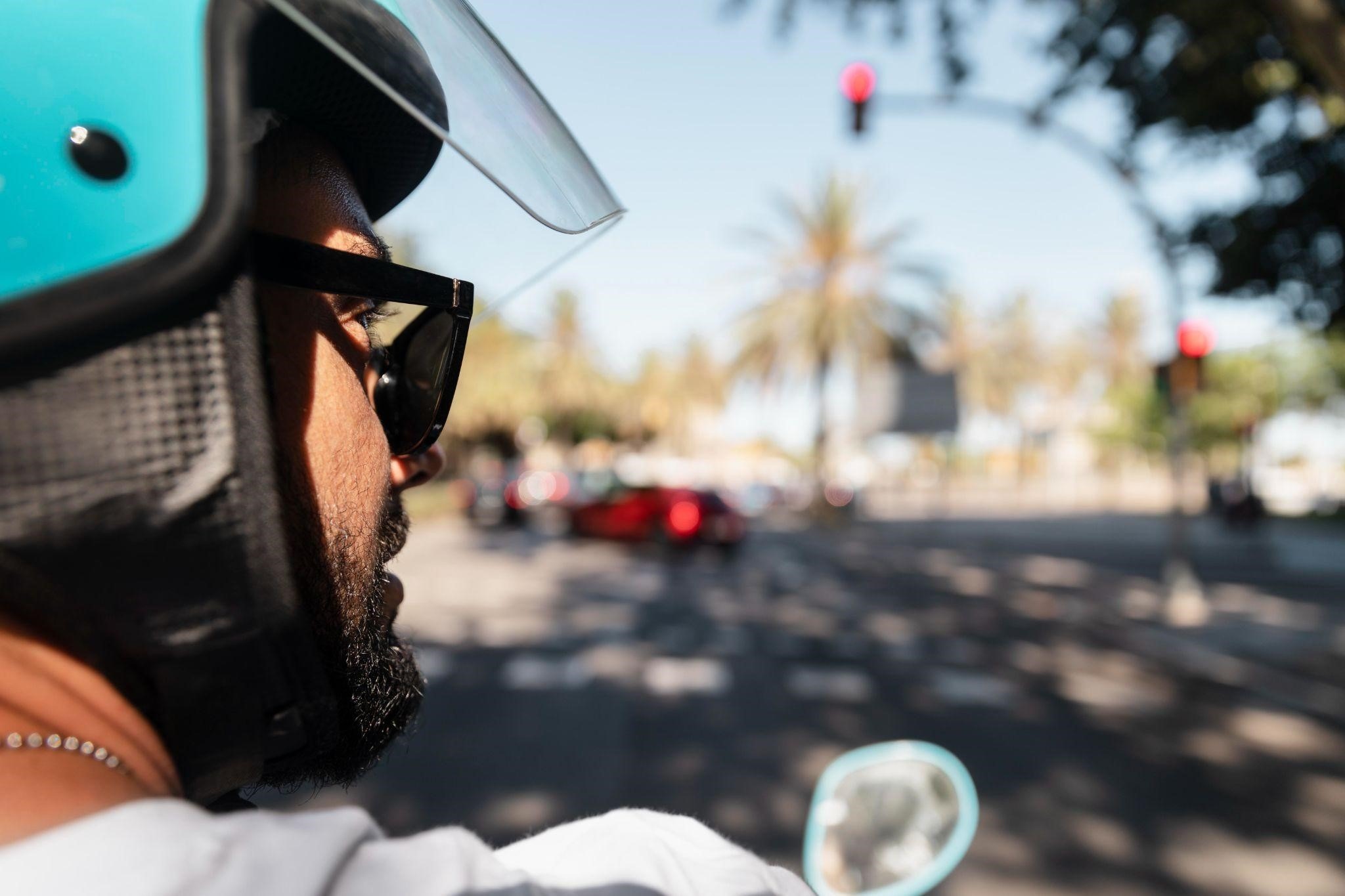 a guy wearing helmet while driving on the road