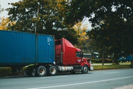 Red semi-truck with blue shipping container