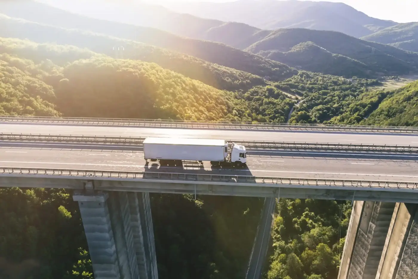 Trucks on highway in mountain at sunset